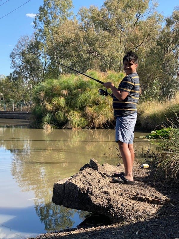 A participant fishing on the riverbank