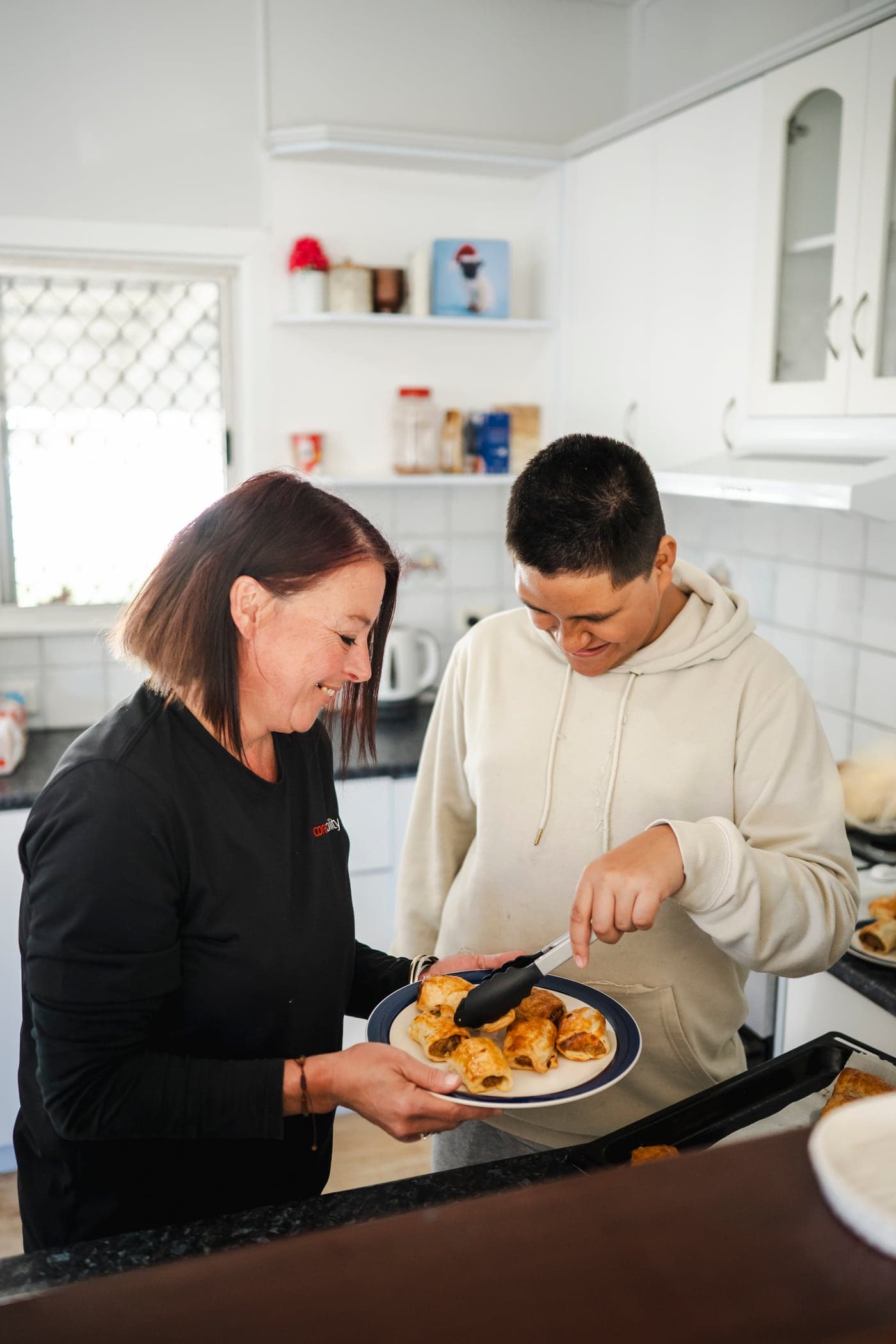 A Coreability support worker helping a participant in the kitchen