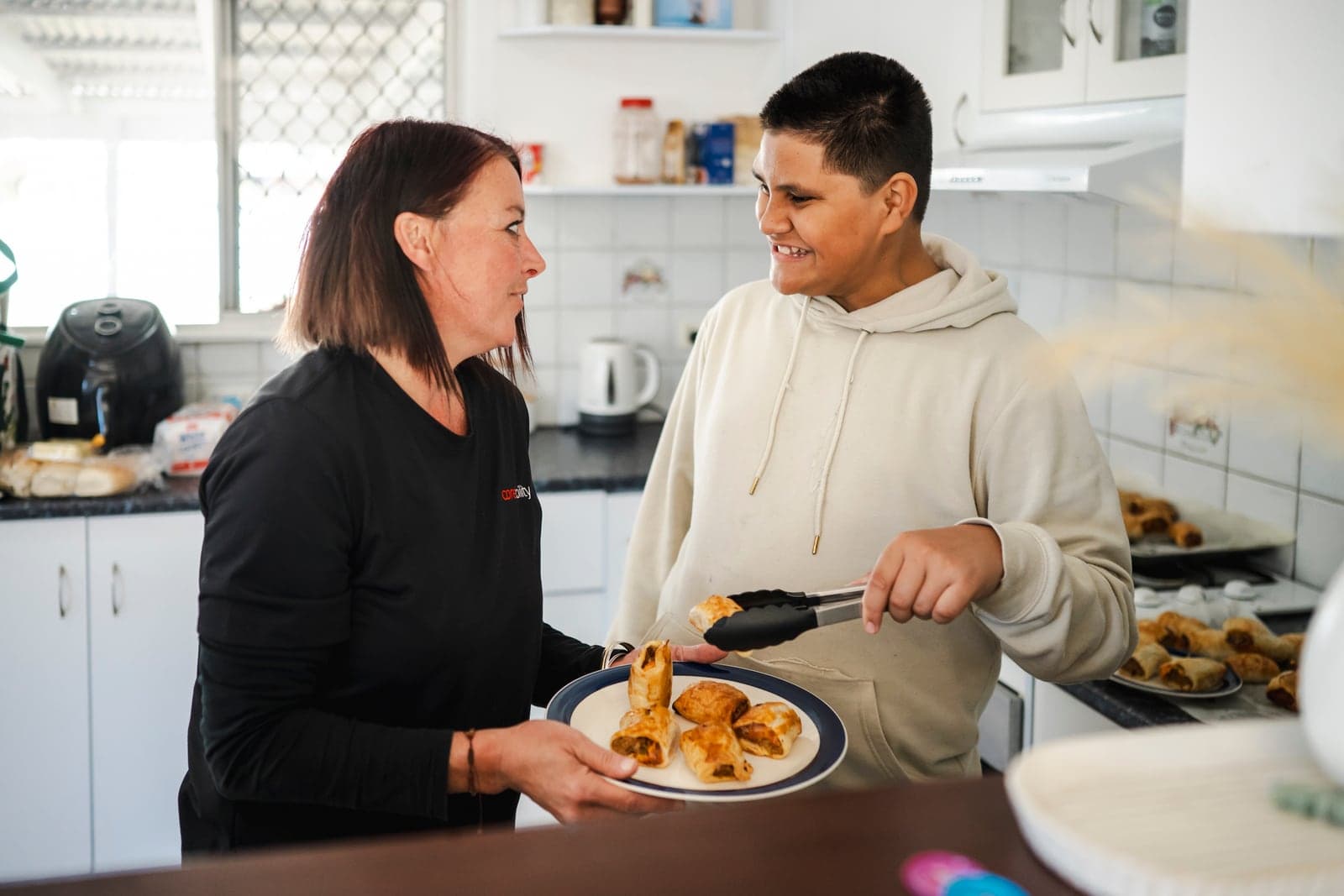 A Coreability support worker and participant cooking together