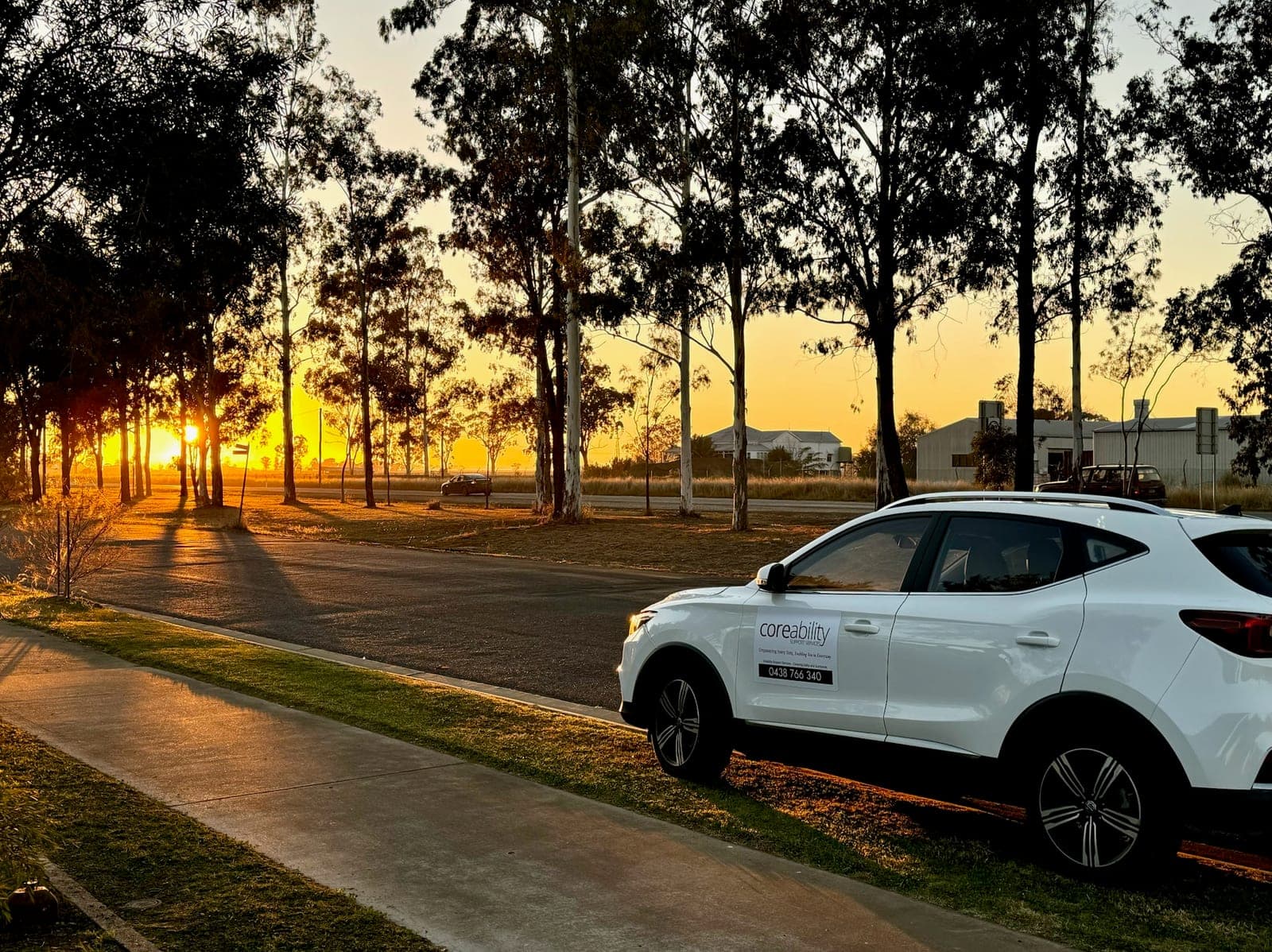 A Coreability branded vehicle on a country road at sunset